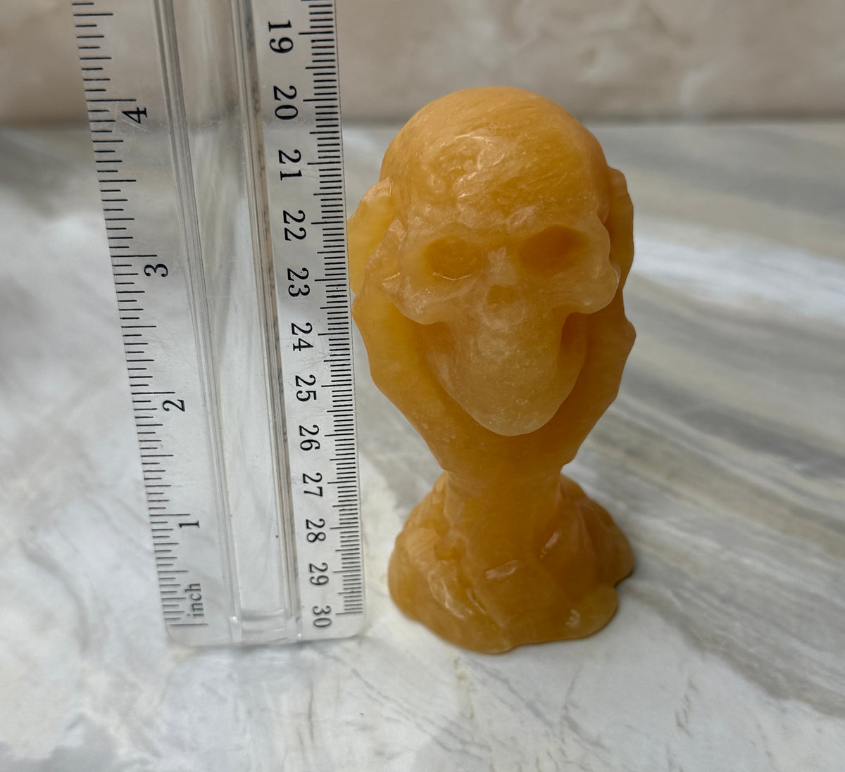 Orange Calcite Skull in Hand Carving