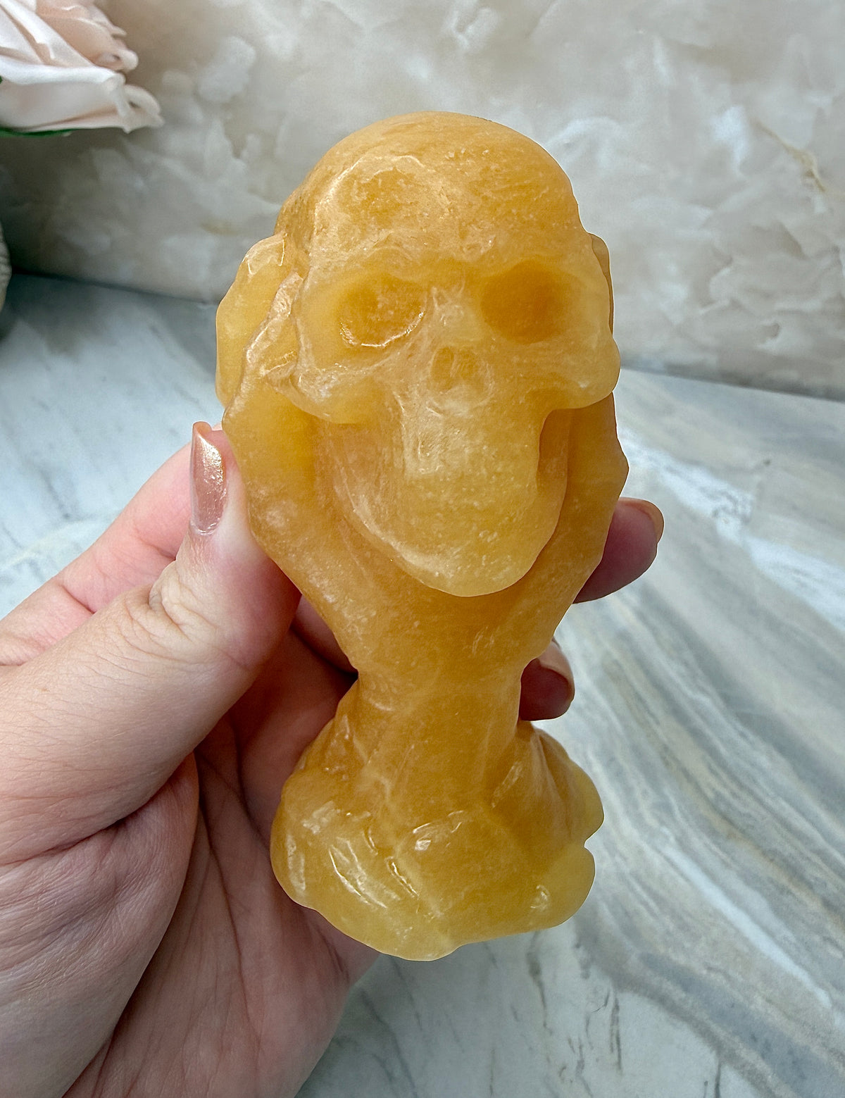 Orange Calcite Skull in Hand Carving