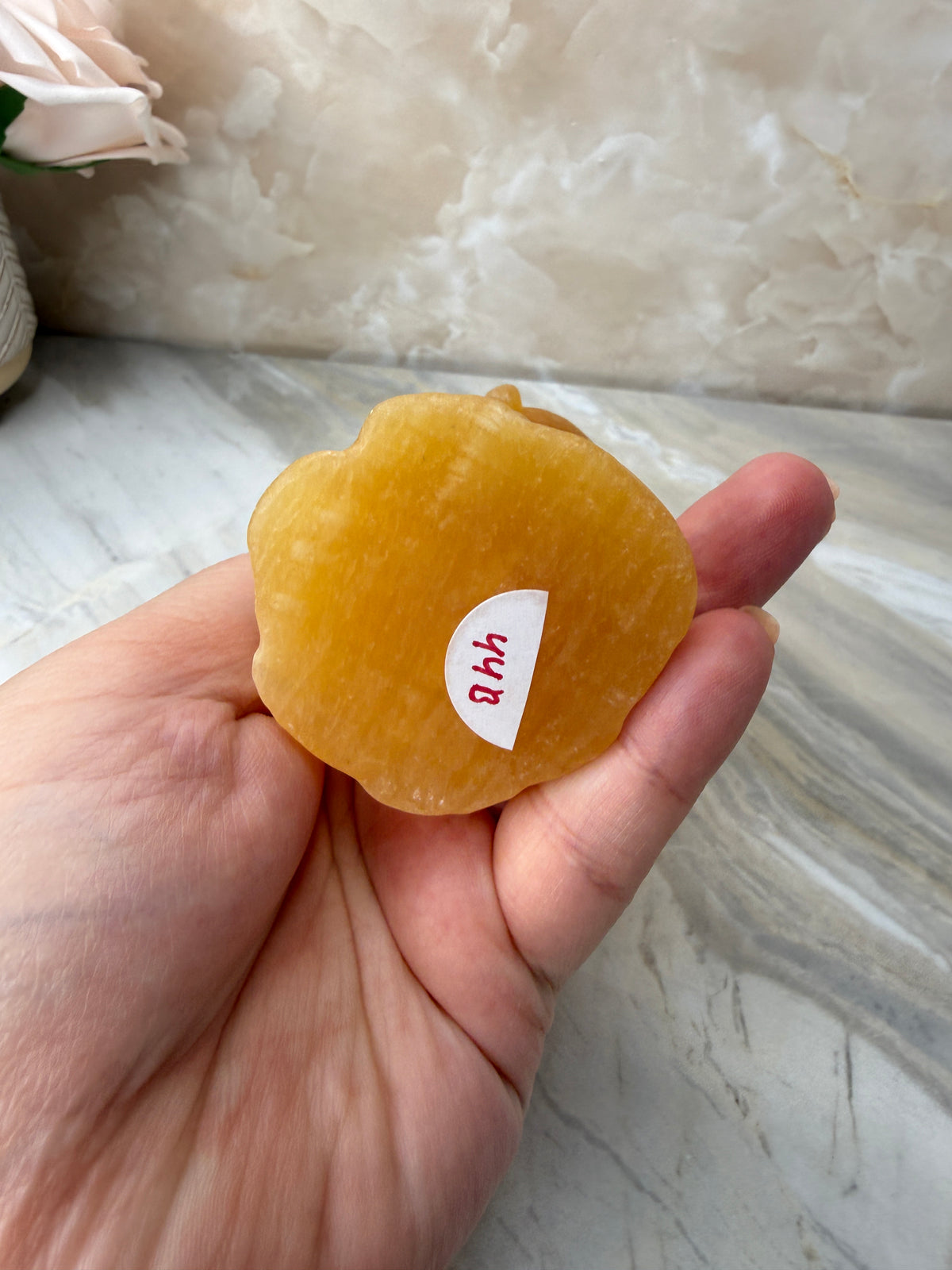 Orange Calcite Skull in Hand Carving