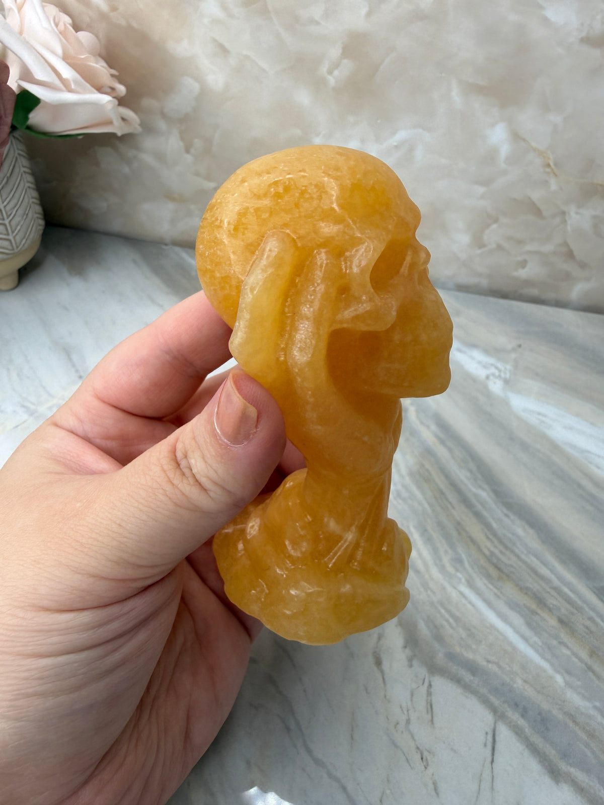 Orange Calcite Skull in Hand Carving