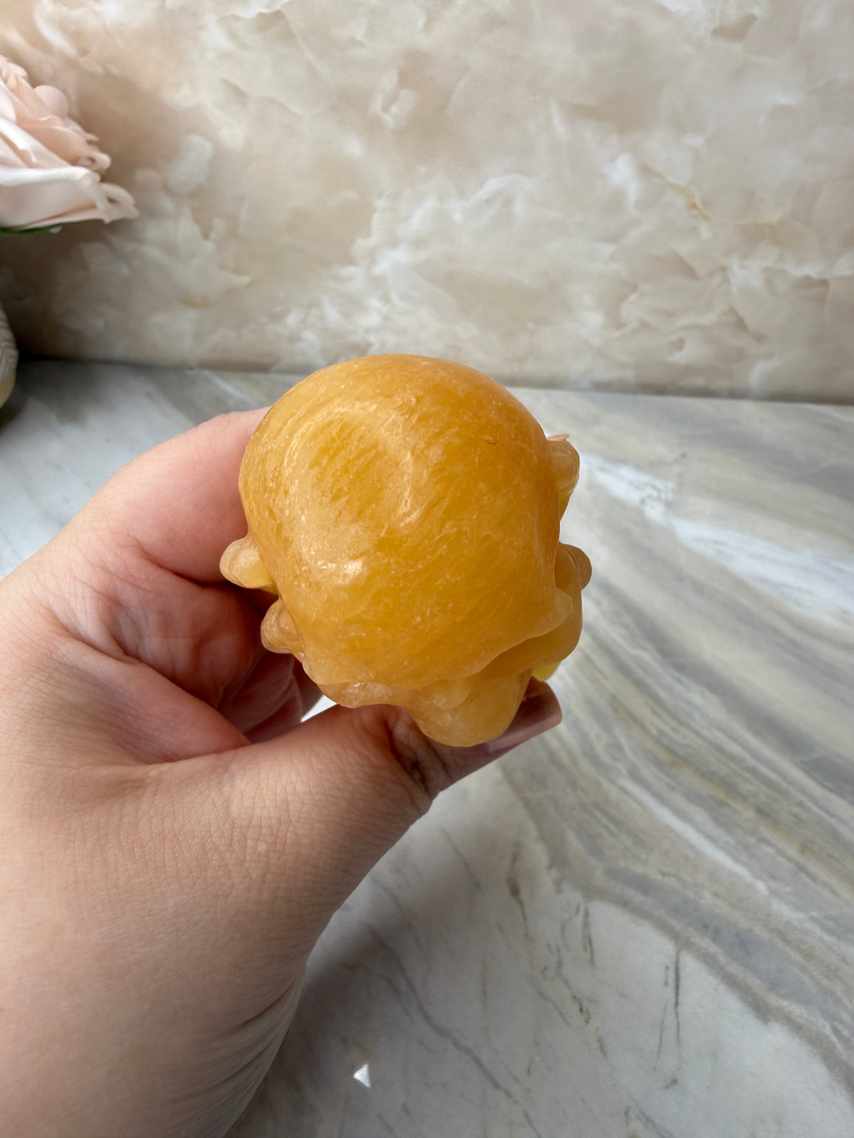 Orange Calcite Skull in Hand Carving
