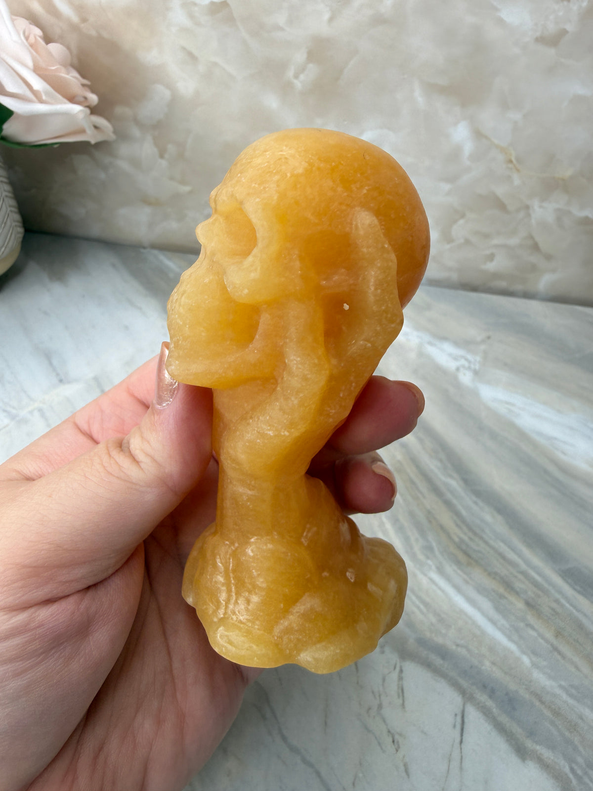 Orange Calcite Skull in Hand Carving